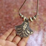 Main tenant un bijou en argent, un collier