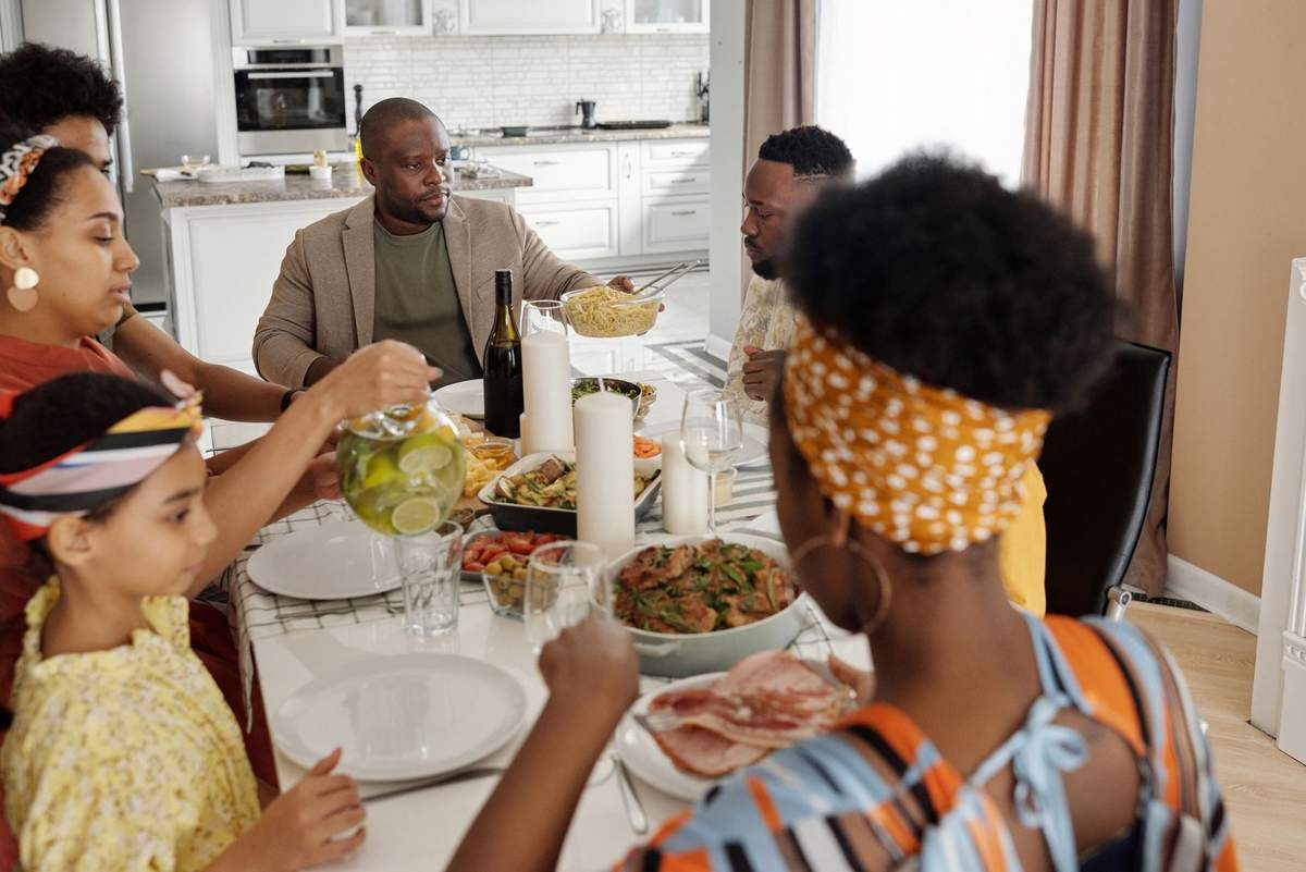 Famille diverse déjeune ensemble dans une cuisine lumineuse Famille diverse déjeune ensemble dans une cuisine lumineuse